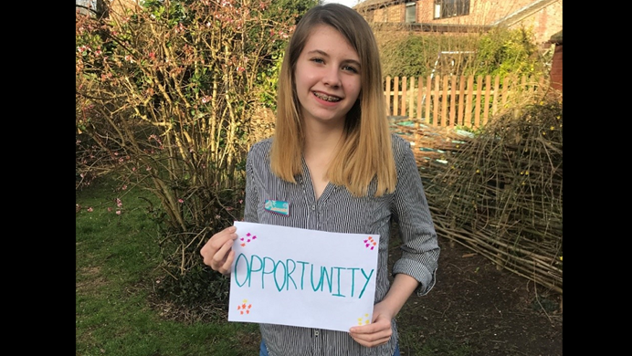 Young woman holding hand written sign that says opportunity